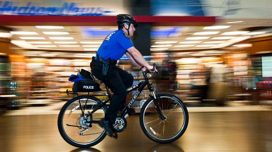 Officer riding a bike through an indoor setting.