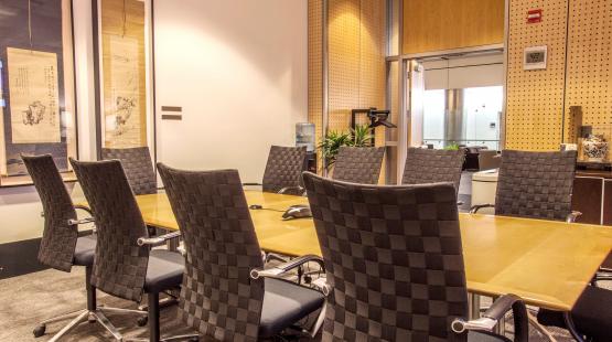 View of the Tokyo boardroom showing the wooden table, with 10 chairs set around the table.