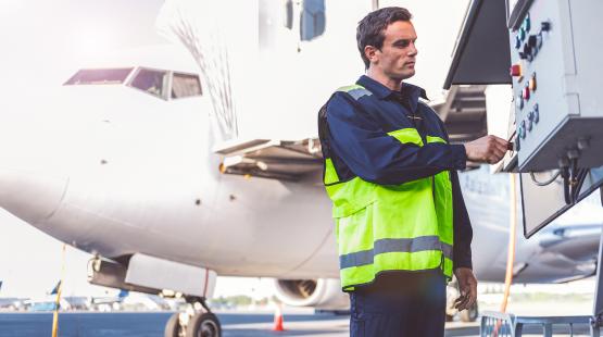 Airfield worker toggles the controls of a et bridge