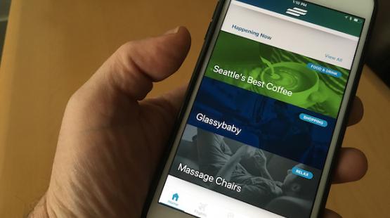 Person holding a phone with the SEA Airport App open