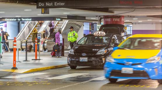 Customers taking the escalator to the terminal and taxis approaching the 3rd floor of the parking garage
