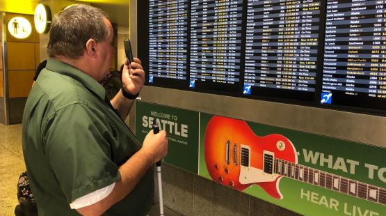 Larry Watkinson uses Aira assistive technology to help him navigate SEA.