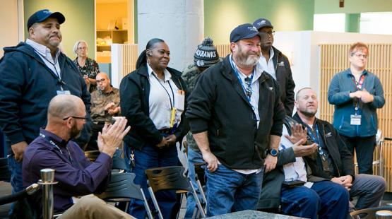 Members of the AV Maintenance Field Crew Garage Team stand to be recognized by their peers