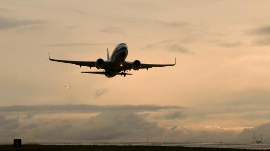 Ascending airplane shortly after takeoff silhoutted on a pink sky, SEA Airport, Nov. 2008