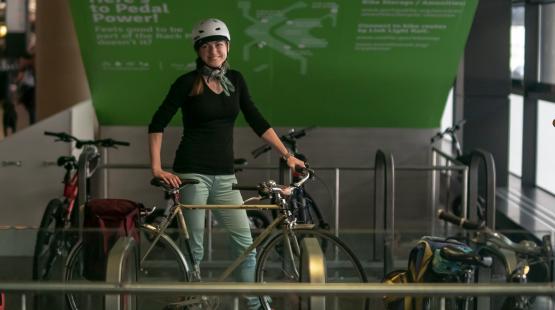Traveler smiling with bike and entering the rack locations on baggage claim. 