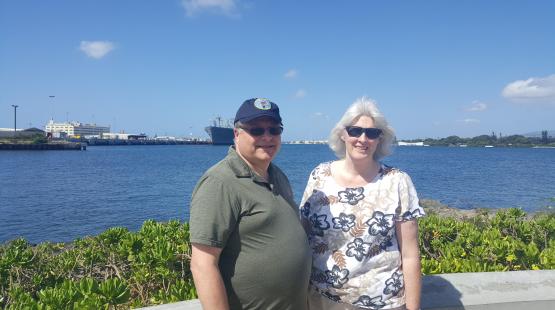 Duane Gibb and his wife standing in front of water