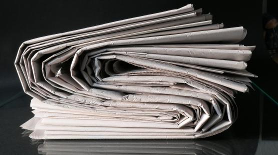 Stacked newspapers viewed from the side.