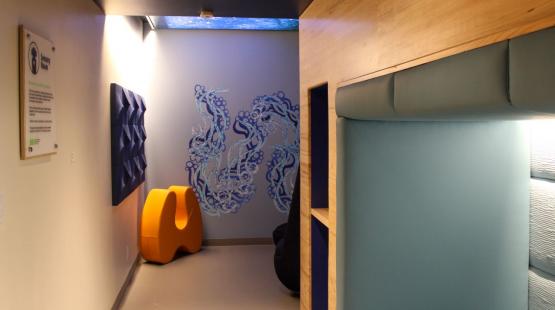 The inside of the sensory room with seating nook, furniture, and artwork