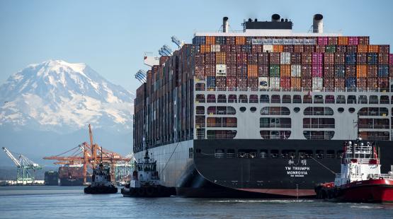 Cargo ship gets piloted by tugs into the Port of Tacoma WA