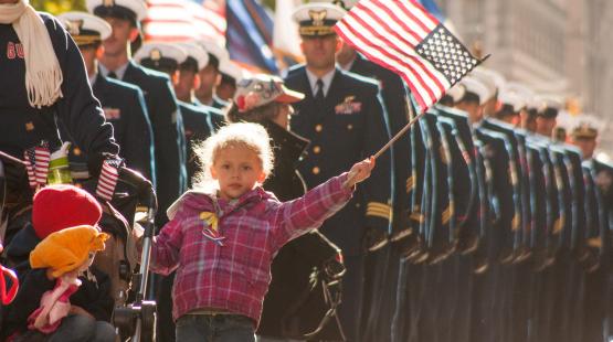 Young girl waves a flag at Veterans Day Parade in New York City