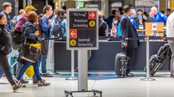 People traveling through a TSA security checkpoint at SEA Airport