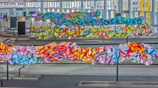 Colorful artwork called Chalchiuhtlicue in the International Arrivals Facility at SEA