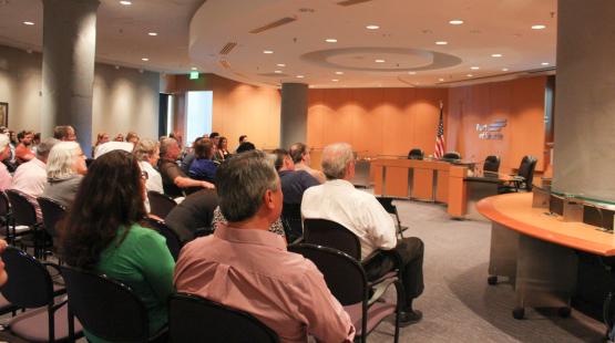 Audience members seated in rows facing a presentation area in a Port of Seattle meeting room.