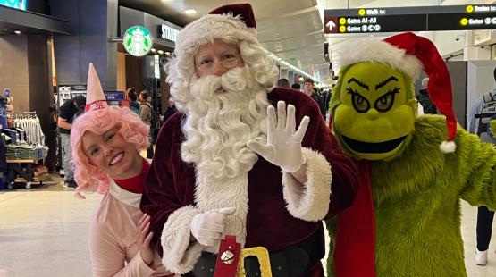 People dressed as Santa and other holiday characters at SEA Airport
