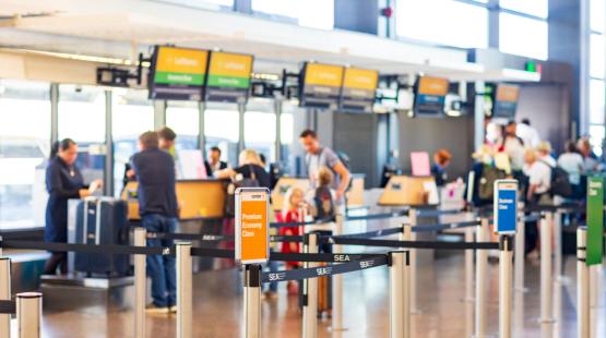 Travelers checking baggage at SEA Airport
