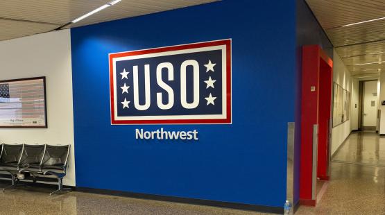 Wall sign reading 'USO Northwest' in an airport hallway.