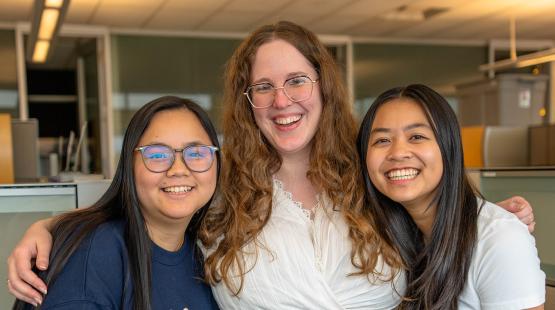 Dianne, Trudy, and Raeanna, stand close together in an office setting.