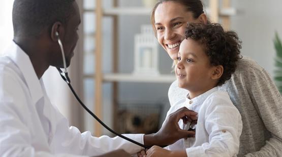 Doctor listening to child's heart.